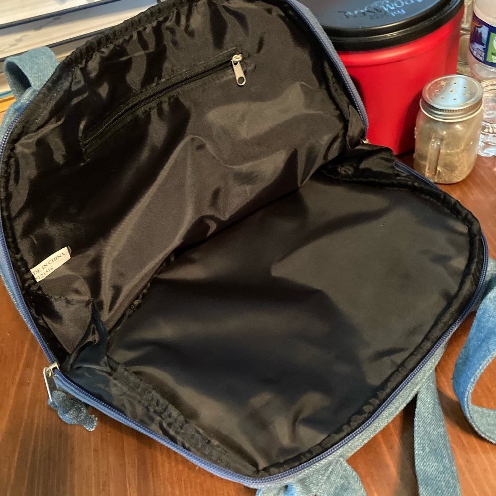 A blue Jean pocket book back pocketbook opens all the way to carry a book in